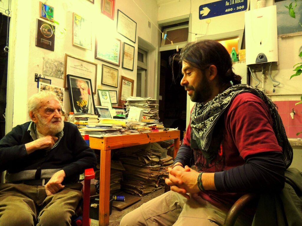 Fernando "Catuto" Ojeda junto a Osvaldo Bayer en su casa del barrio de Belgrano, Buenos Aires, conocida como "El Tugurio" como la bautizó su amigo, el escritor Osvaldo Soriano. Agosto del año 2016. En el sur, los porteños le dicen tugurio a casas que tienen cierto desorden y de poco espacio.